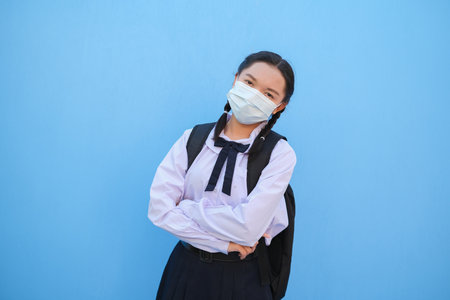 School girl wear mask on blue background,Back to school.の写真素材