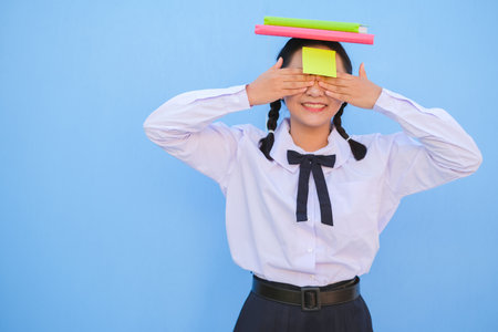 Student with book and small note paper on blue background.の写真素材