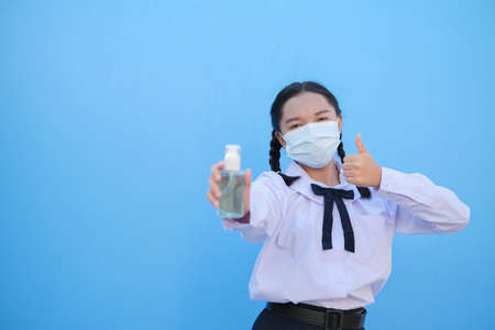 School girl wear mask on blue background,Back to school.の写真素材