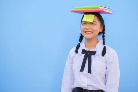 Student with book and small note paper on blue background.の写真素材