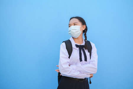 School girl wear mask on blue background,Back to school.の写真素材