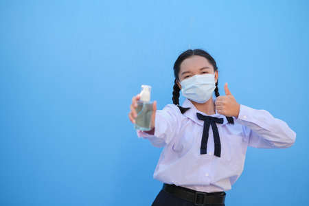 School girl wear mask on blue background,Back to school.の写真素材