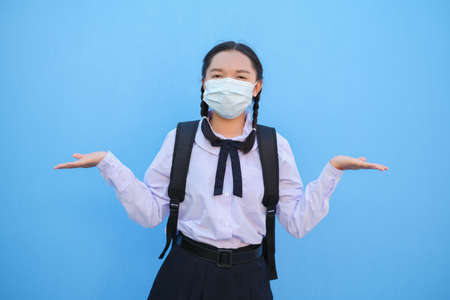 School girl wear mask on blue background,Back to school.の写真素材