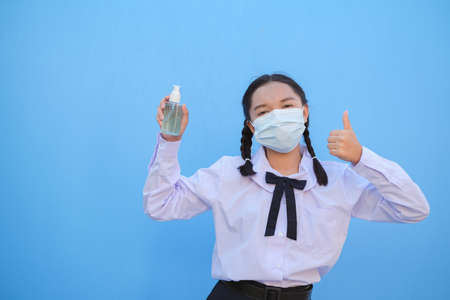 School girl wear mask on blue background,Back to school.の写真素材