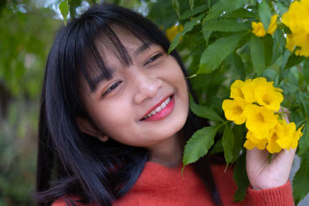 Portrait young girl with yellow flowers, Asian girl.