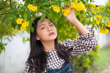 Portrait young girl with yellow flowers, Asian girl.の写真素材