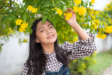 Portrait young girl with yellow flowers, Asian girl.の写真素材