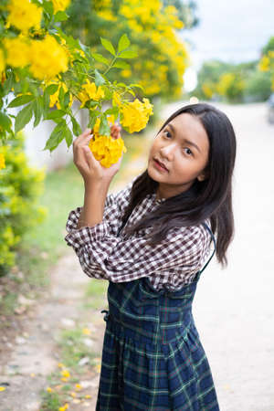 Portrait young girl with yellow flowers, Asian girl.の写真素材
