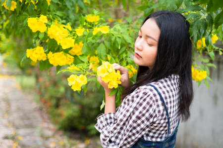 Portrait young girl with yellow flowers, Asian girl.の写真素材
