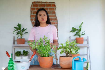Portrait happy young girl with green plants at home, Asian girl.の写真素材