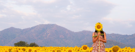 The beautiful girl hold sunflower with beautiful flower filed.の写真素材