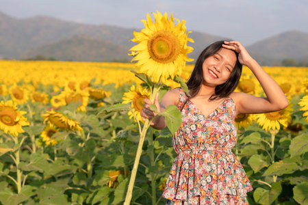 Beautiful young girl enjoy time at the field flowers.の写真素材