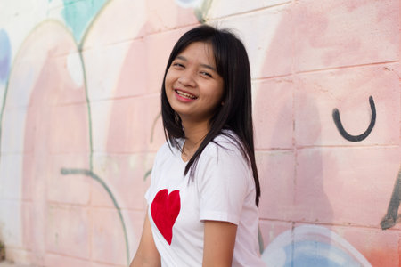 Portrait close-up face Asian young girl wearing t-shirt with heart on colorful background.の写真素材