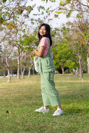 The girl carrying cloth bag walking in the garden, student girl.の写真素材
