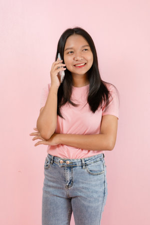 Beautiful young girl hold smart phone on pink background.の写真素材