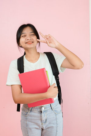 Happy student young girl hold pink book and backpack on pink background.の写真素材