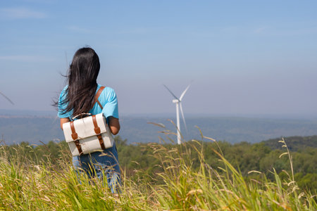 Traveler girl turn back looking beautiful view of mountain and Wind Turbine, Khao Yai Thieng Electric Wind Turbine Thailand.の写真素材