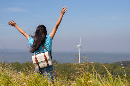Traveler girl turn back looking beautiful view of mountain and Wind Turbine, Khao Yai Thieng Electric Wind Turbine Thailand.の写真素材