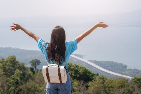 young girl with backpack, hat and looking at amazing mountains and Wind Turbine on the mountain,space for text, Khao Yai Thieng Thailand.の写真素材