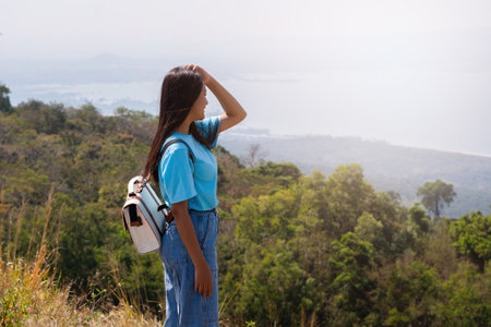young girl with backpack, hat and looking at amazing mountains and Wind Turbine on the mountain,space for text, Khao Yai Thieng Thailand.の写真素材