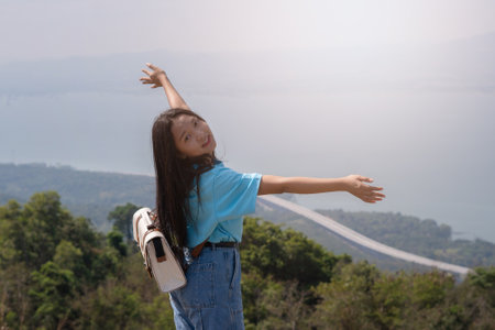 young girl with backpack, hat and looking at amazing mountains and Wind Turbine on the mountain,space for text, Khao Yai Thieng Thailand.の写真素材