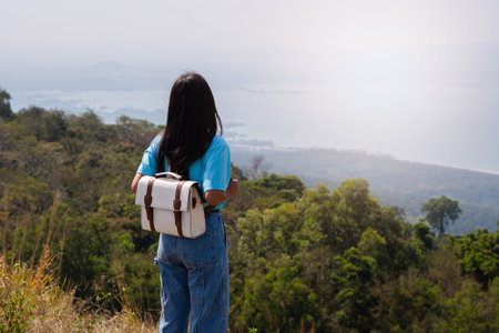 young girl with backpack, hat and looking at amazing mountains and Wind Turbine on the mountain,space for text, Khao Yai Thieng Thailand.の写真素材