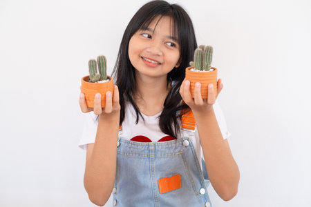 Happy young girl smiling and showing cactus on white background.の写真素材