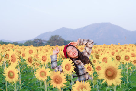 Smile young girl at sunflower field in the morning.の写真素材