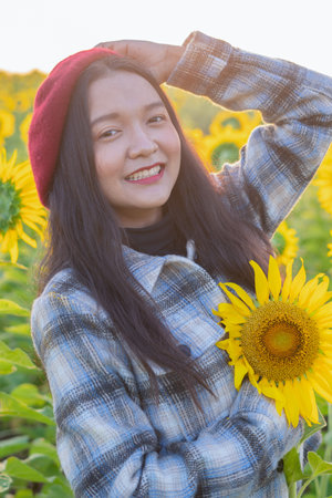 Happy young girl standing in the sunflowers field on vacation time.の写真素材
