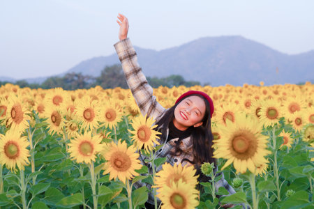 Smile young girl at sunflower field in the morning.の写真素材