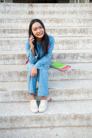 School girl Smiling and sitting on stair hold book at school.の写真素材