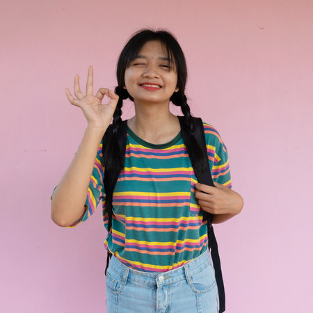 Student young girl hold book standing on pink background.の写真素材