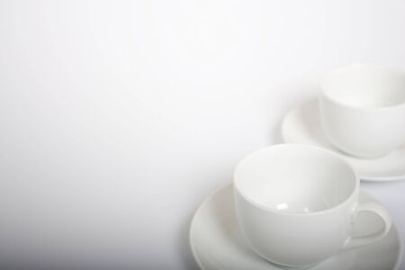 Two empty coffee cups on the lower right-hand side of a light frameの写真素材