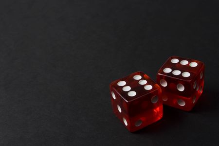 Two Red Dice on the lower right-hand side of a dark backgroundの写真素材