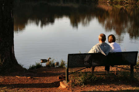 Old couple feeding ducksの写真素材