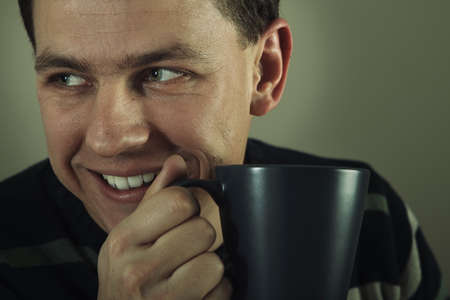 Portrait of man drinking hot beverage. Relatively short DoF. Sharp face, eyes.の写真素材