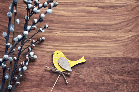 Bird yellow on the willow branches. Easter topper. Spring holiday mood. Wooden background. Rustic style.の写真素材