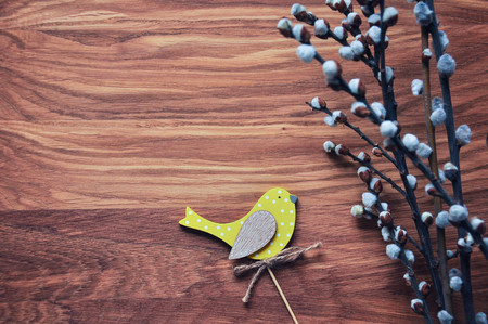 Bird yellow on the willow branches. Easter topper. Spring holiday mood. Wooden background. Rustic style.の写真素材