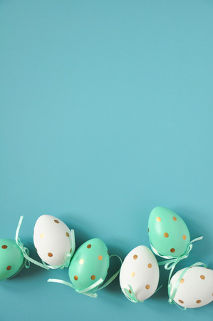 Easter eggs are white blue polka dots. Festive mood. Easter attributes. Easter food. Drawing on the eggs. White pink blue easter backgroundの写真素材