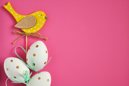 Easter eggs are white blue polka dots. Festive mood. Easter attributes. Drawing on the eggs. Pink...