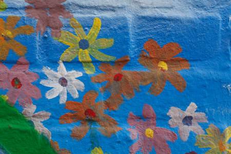 Blue Bricks and painted Flowers  in a  brick Wallの写真素材