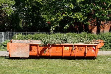Orange Absetzmulde mit PflanzenabfÃ¤llen auf einer Wiese stehend,  Deutschland, Europa