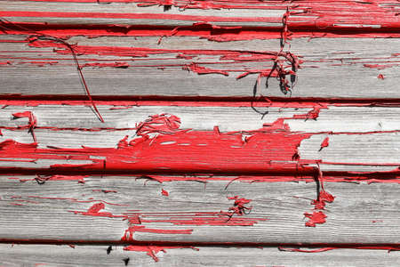 Old, red wooden boards with peeling paint, background picture, textureの写真素材