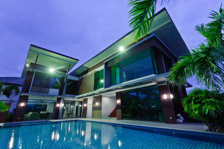 Modern house with swimming pool at nightの写真素材
