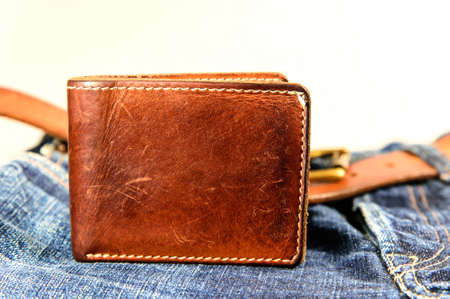Brown leather wallet on jeans background