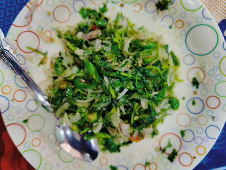 Fried kale with onion in a plate on the tableの写真素材