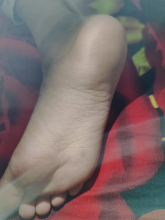 Feet of a girl on a background of a colored fabric.
