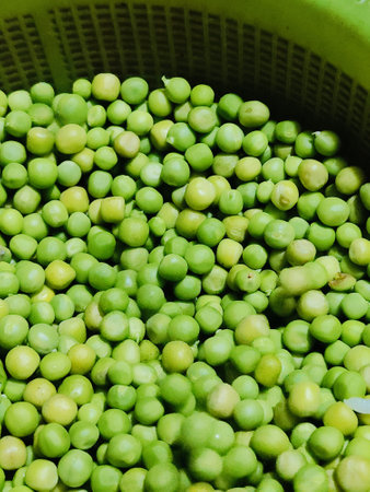 Green peas in a basket on a market stall, closeup of photoの写真素材