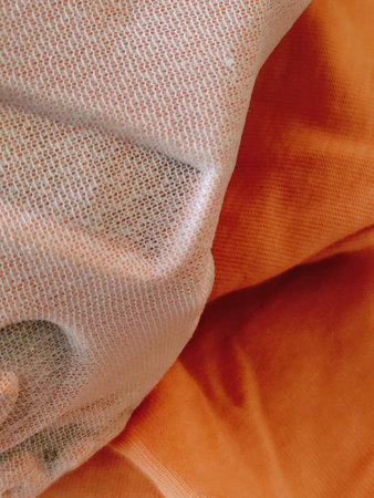 Close-up of a crumpled orange fabric texture background.