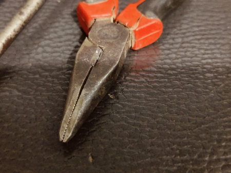 Old pliers on a leather background, close-up of photo